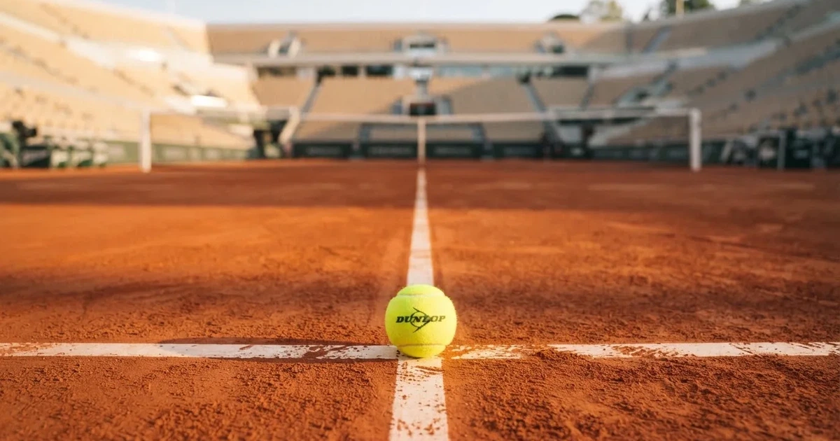 Un balón en el punto central de un campo de césped a la luz de la mañana